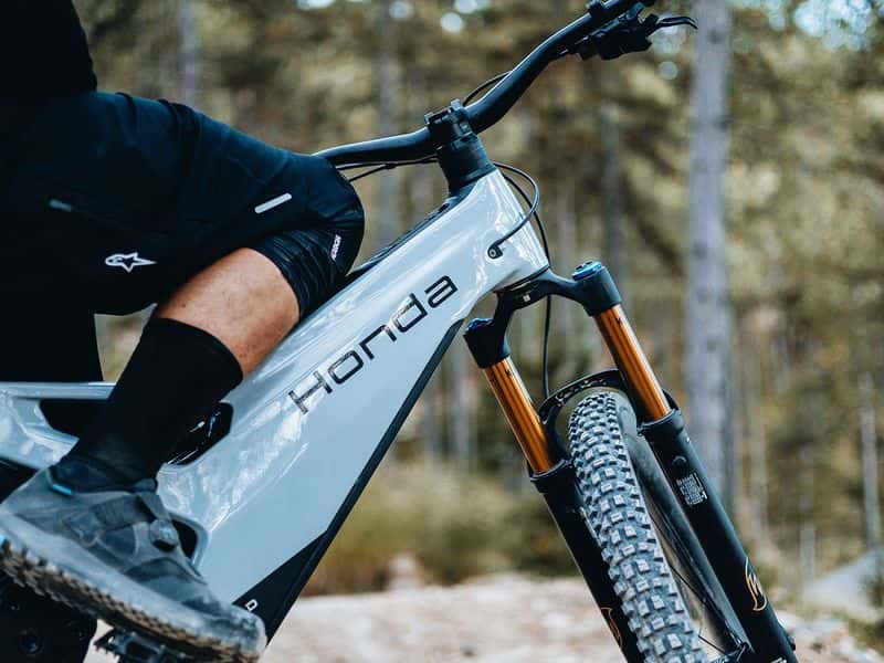 Honda eMTB prototype on a forest trail, rider detail