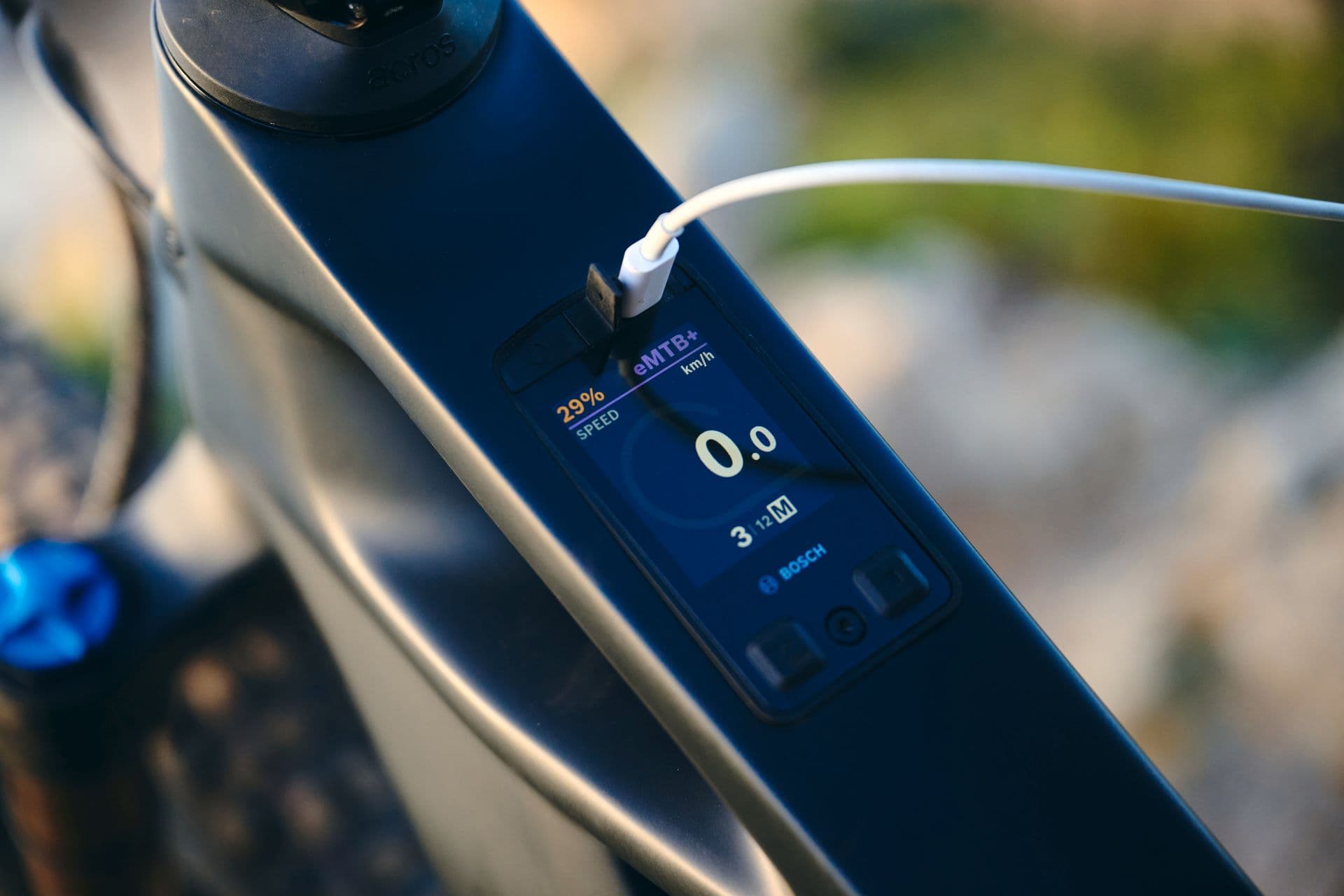 Bosch Kiox 400C display integrated in an e-MTB top tube, with a USB-C cable plugged in