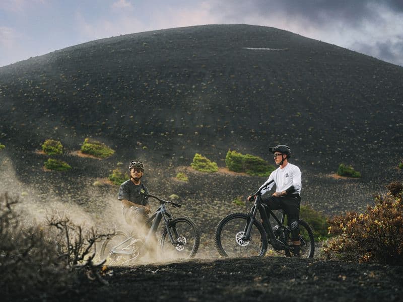 Two riders on Mondraker Zendit e-MTBs on a volcanic trail