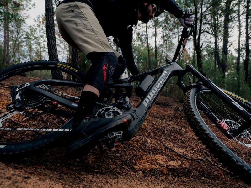 Propain e-MTB with SRAM Eagle Transmission derailleur cornering on a forest trail
