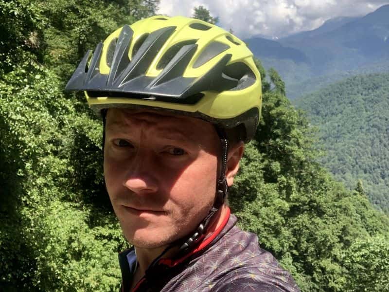 Ilya Alikov, editor of eMTB Magazine, in a bike helmet on a mountain trail