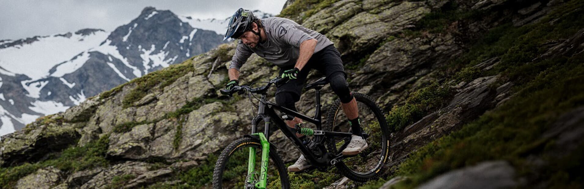 Rider descending a rocky alpine slope on Pirelli Scorpion gravity mountain bike tyres