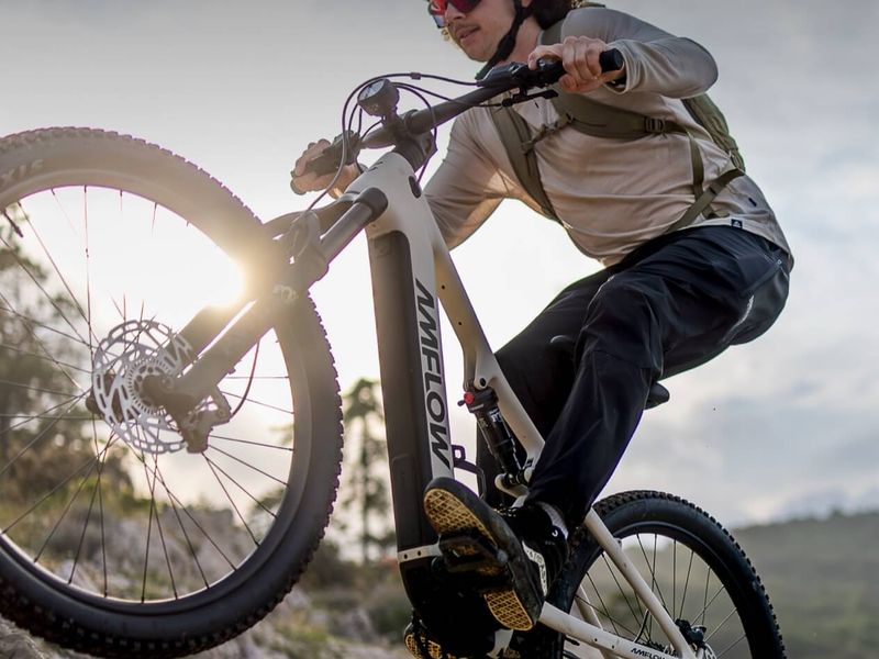 Rider on an Amflow TL Carbon climbing over rocks