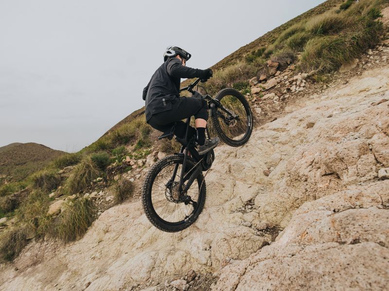 eMTB rider climbing a steep rocky slope on a Bosch Performance Line CX powered e-mountain bike