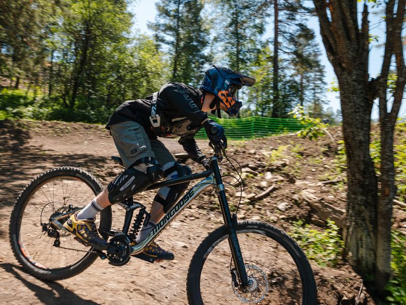 Rider cornering a dirt berm at Manzherok bike park