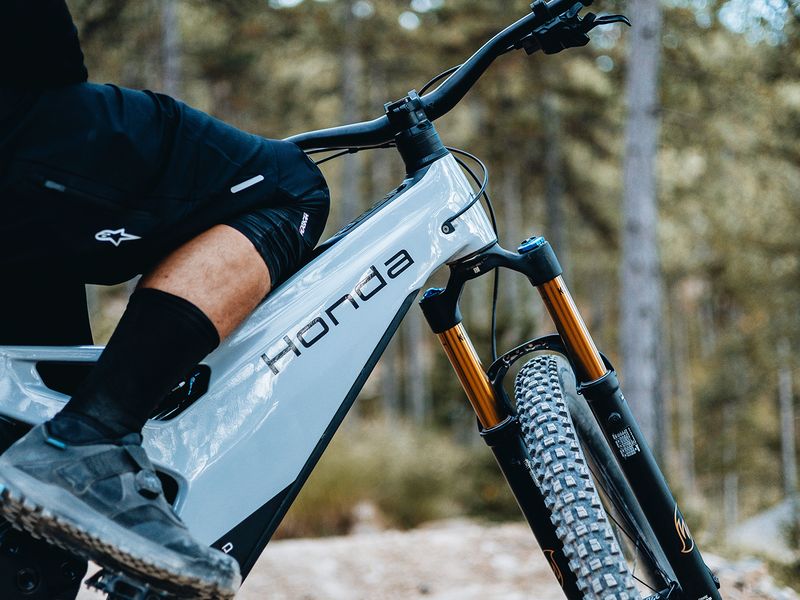 Honda eMTB prototype on a forest trail, rider detail