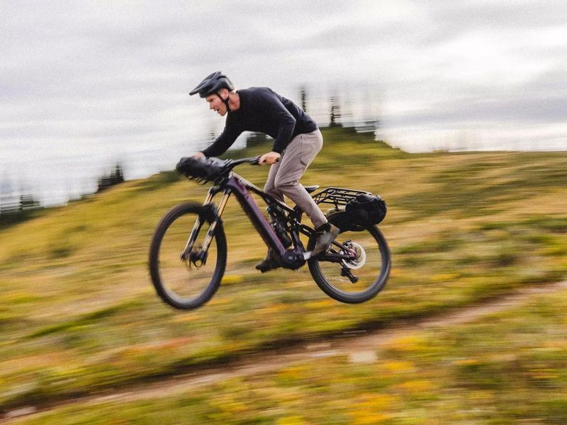 Rider on a loaded Specialized Turbo Levo 4 X on a grassy trail