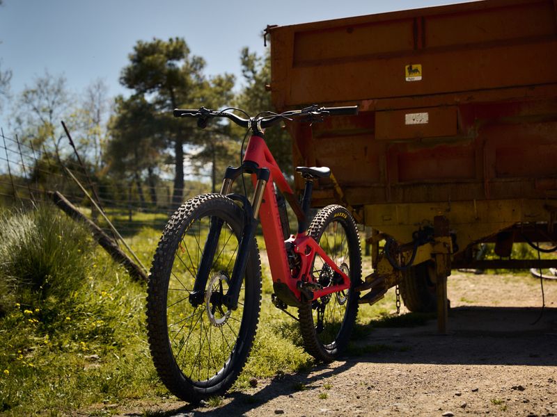 Red Mondraker Neat e-MTB parked next to an old truck