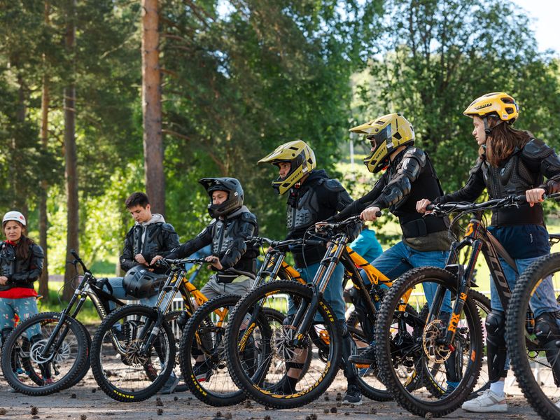 Group of riders with downhill bikes and full-face helmets at Manzherok